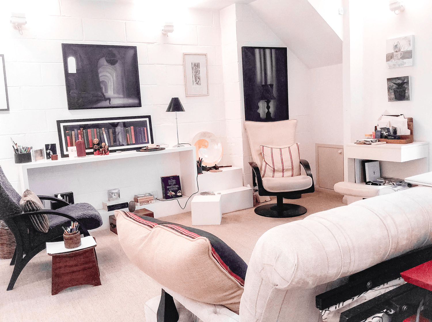 A bright, friendly therapy room with comfy armchairs and interesting artwork.